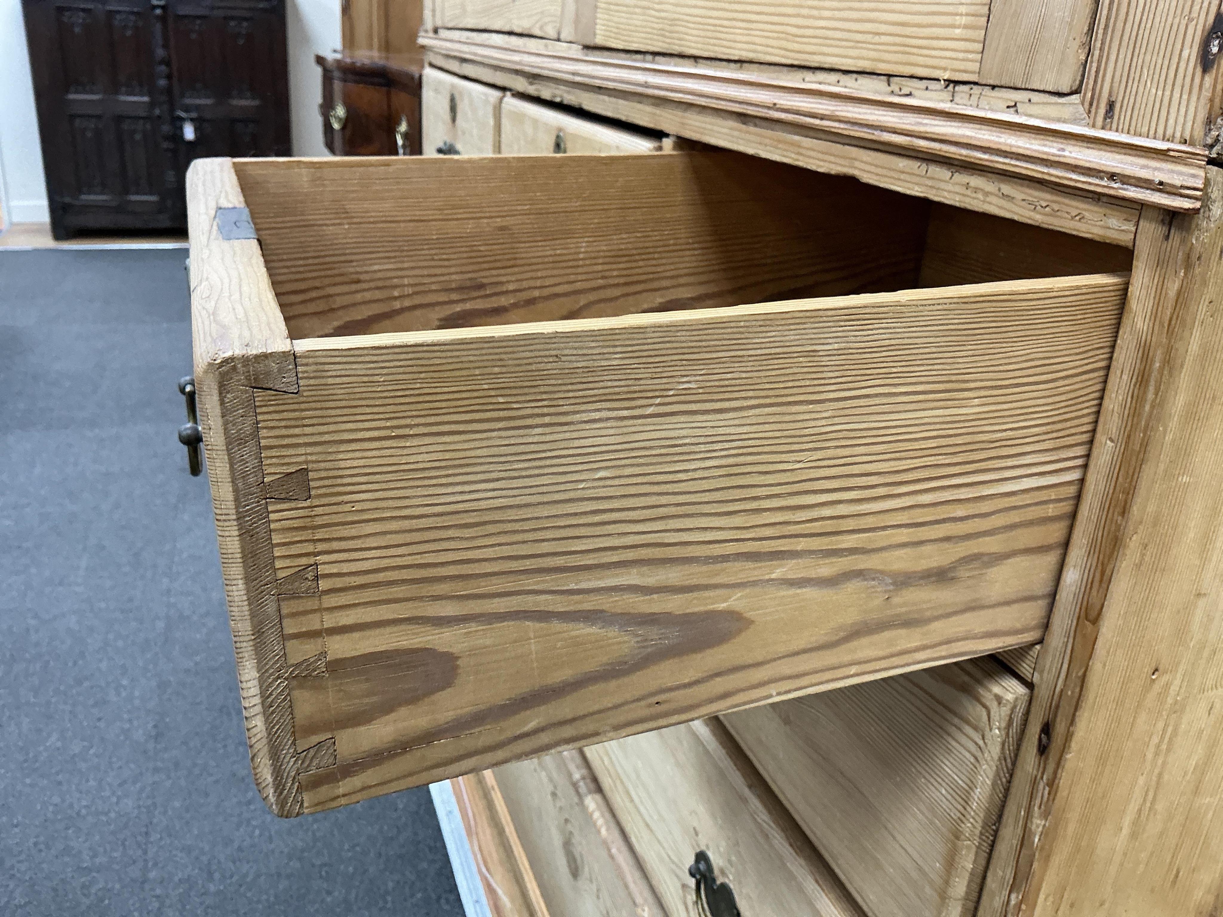 An early 19th century pine two part press cupboard, width 125cm, depth 54cm, height 191cm
